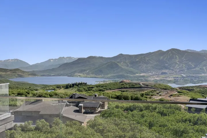 Expansive mountain and lake scenery from a glass-paneled balcony
