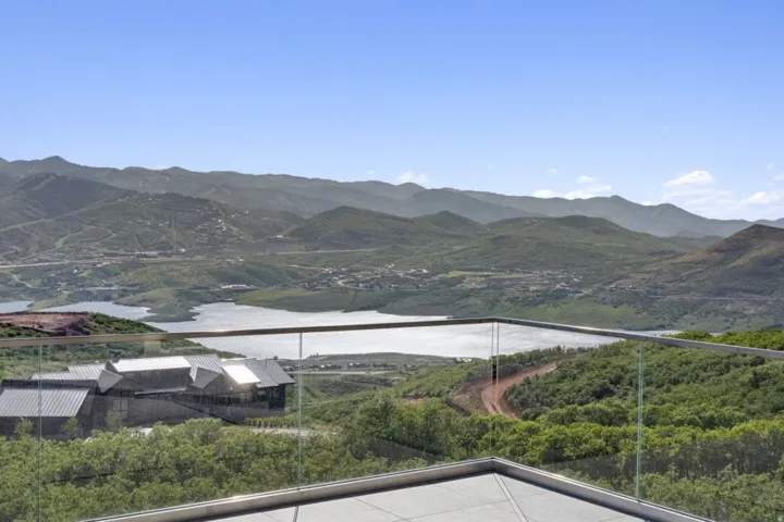 Expansive mountain and lake scenery with a contemporary glass railing
