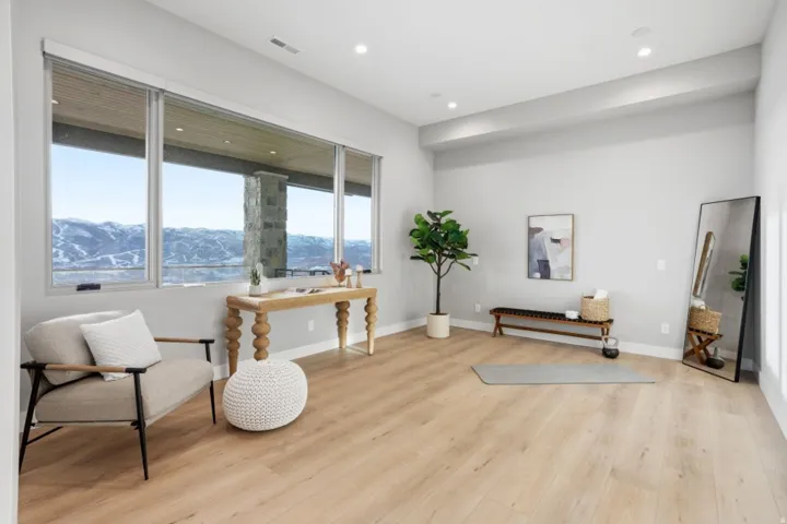 Spacious room featuring floor-to-ceiling windows, wood-finish flooring, recessed lighting, and crisp white baseboards