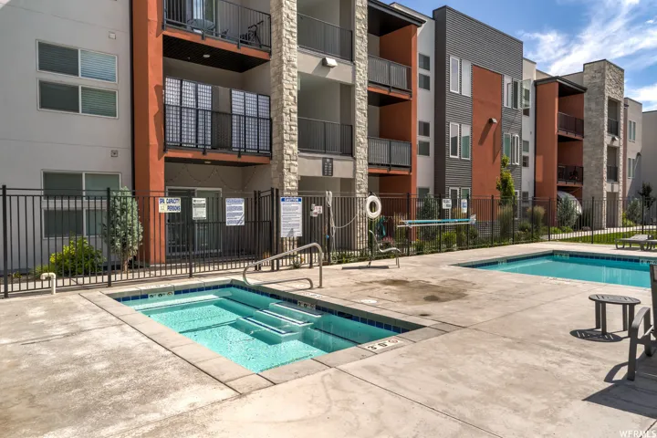 Outdoor spa and swimming pool surrounded by concrete decking