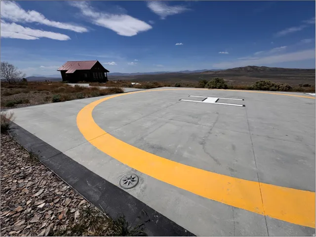 Concrete helipad with yellow markings and a central landing indicator
