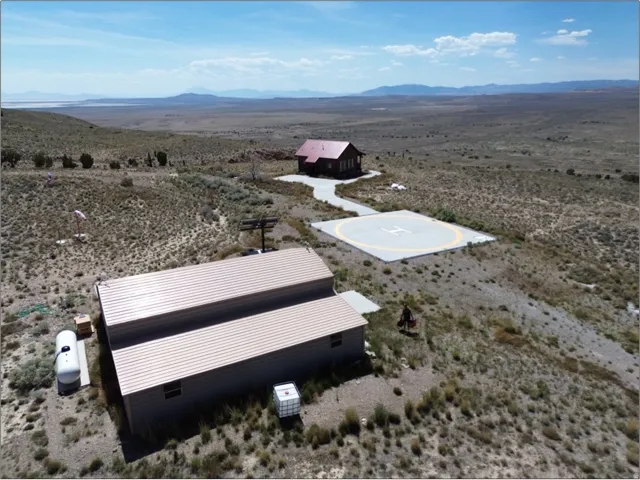 Remote property featuring two structures, a helipad, and expansive desert terrain