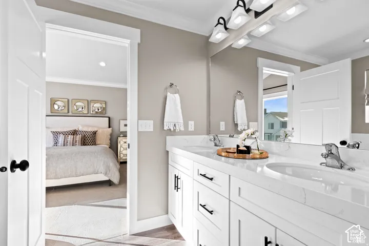 Double vanity featuring white cabinetry with black hardware, undermount sinks, and a large mirror