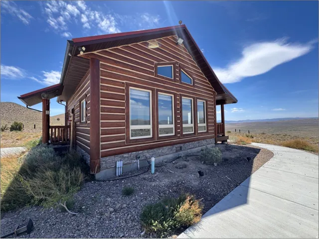 Log-style exterior featuring a reddish-brown wood finish and a red metal roof