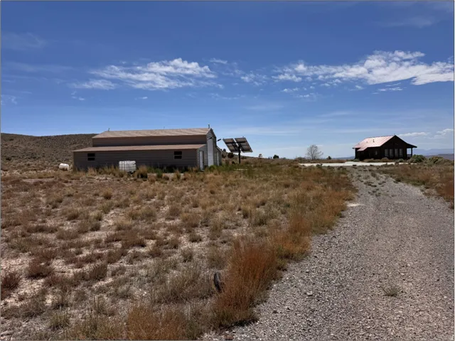 Expansive gravel driveway leading to two distinct structures