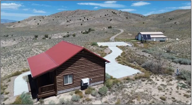 Log cabin-style residence featuring a red metal roof and a covered porch