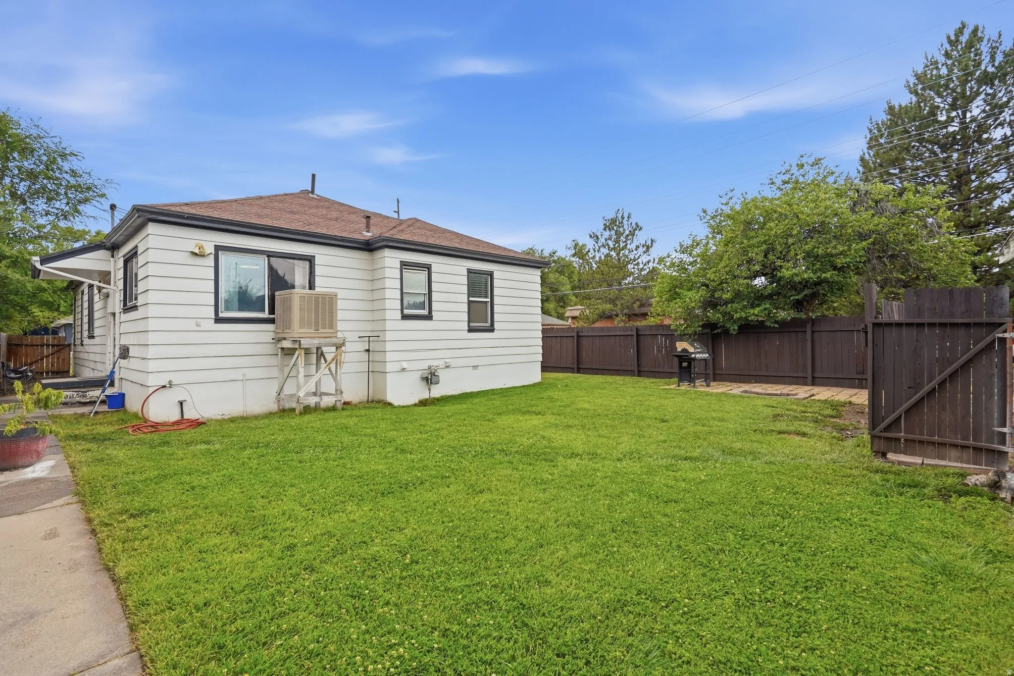 Expansive green lawn with a brown wood privacy fence