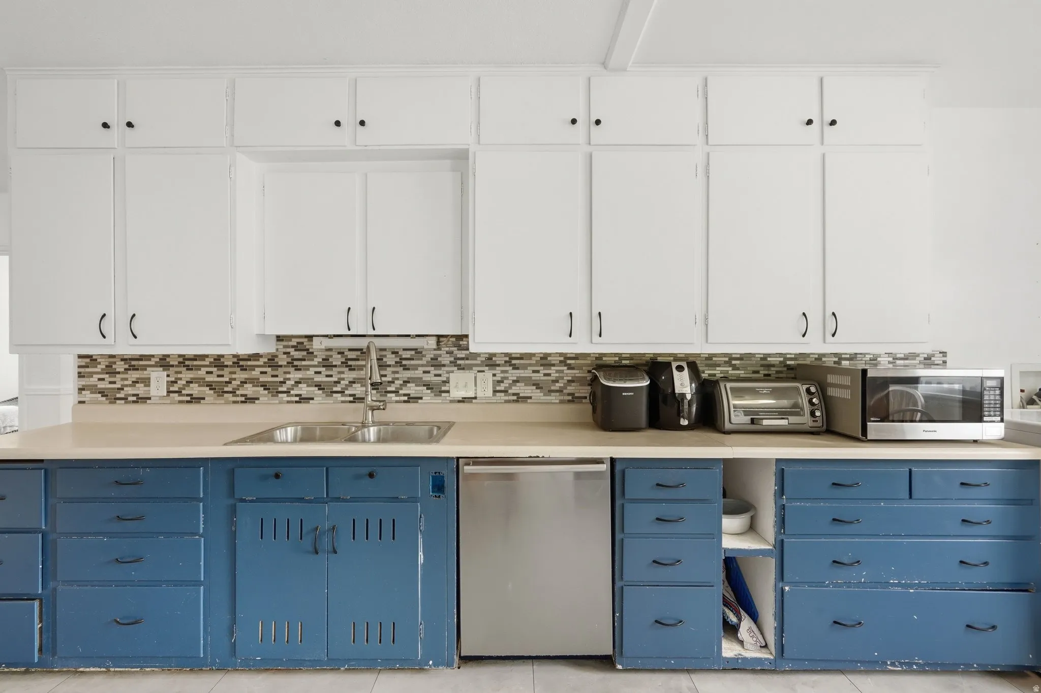 Kitchen featuring two-tone cabinetry with white upper cabinets and blue lower cabinetry
