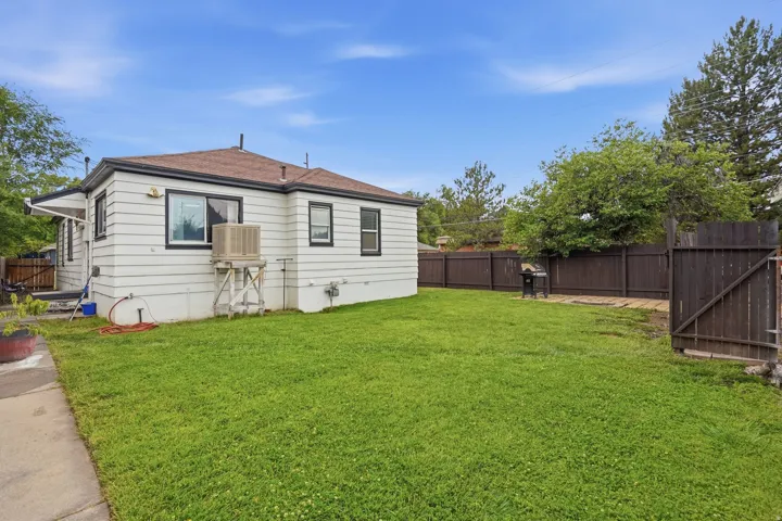 Expansive green lawn with a brown wood privacy fence