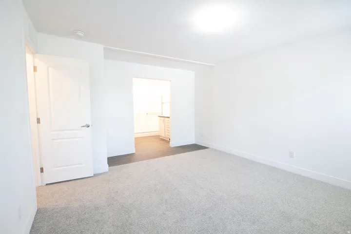Spacious room featuring light gray carpet flooring and white painted walls