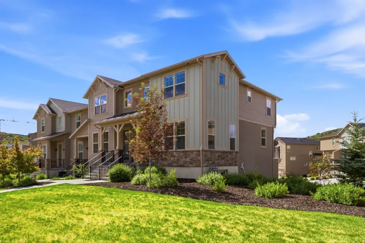 Contemporary townhome featuring stone accents and vertical siding on the facade
