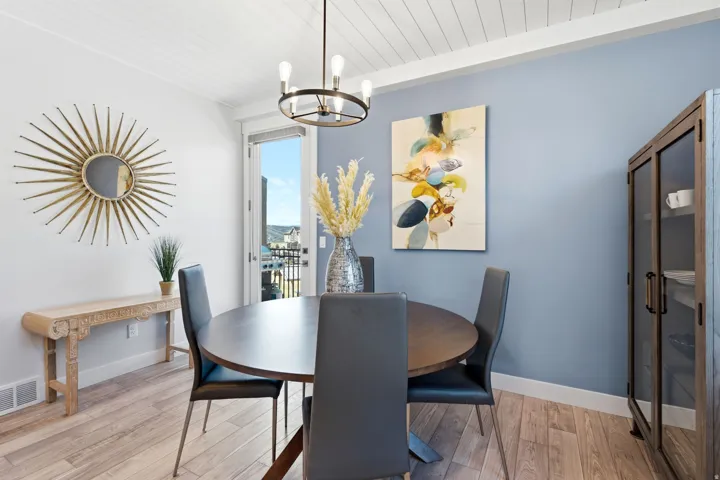 Dining area with light wood-finish flooring and a decorative chandelier