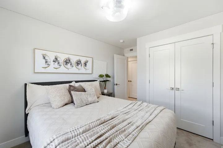 Bedroom featuring a contemporary ceiling light fixture, white walls, and wood-finish flooring