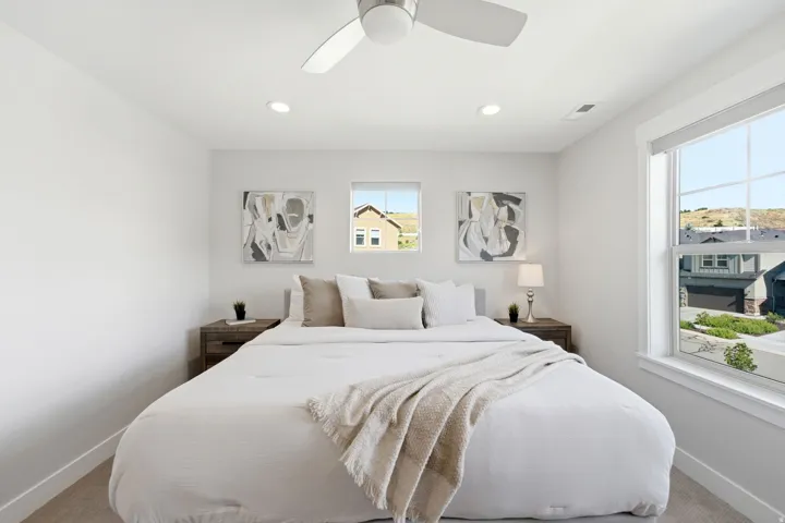 Bedroom featuring a ceiling fan with integrated lighting, recessed ceiling lights, and two large windows with white trim
