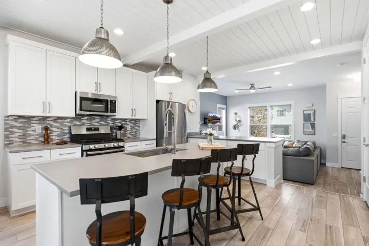 Kitchen featuring white shaker cabinetry, stainless steel appliances, and a mosaic tile backsplash