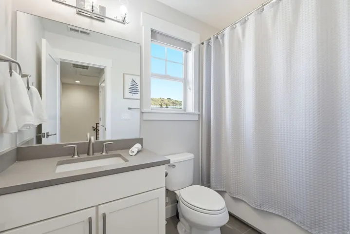 Bathroom with a white vanity featuring a gray countertop and integrated sink