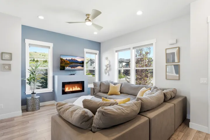 Living area featuring a contemporary fireplace with a built-in television mount, wood-finish flooring, recessed lighting, and a ceiling fan