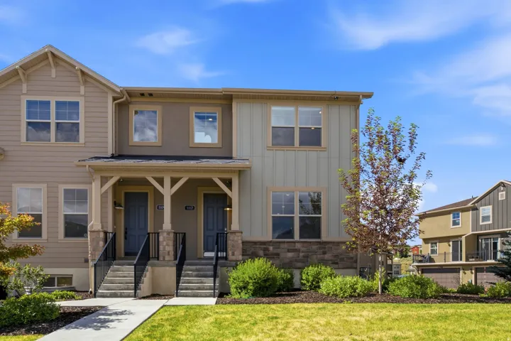 Contemporary multi-unit residence featuring a stone veneer foundation, board and batten siding, and a covered porch entry