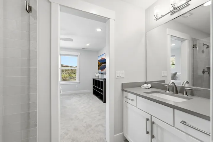 Bathroom vanity featuring a single basin sink, gray countertop, and brushed nickel faucet