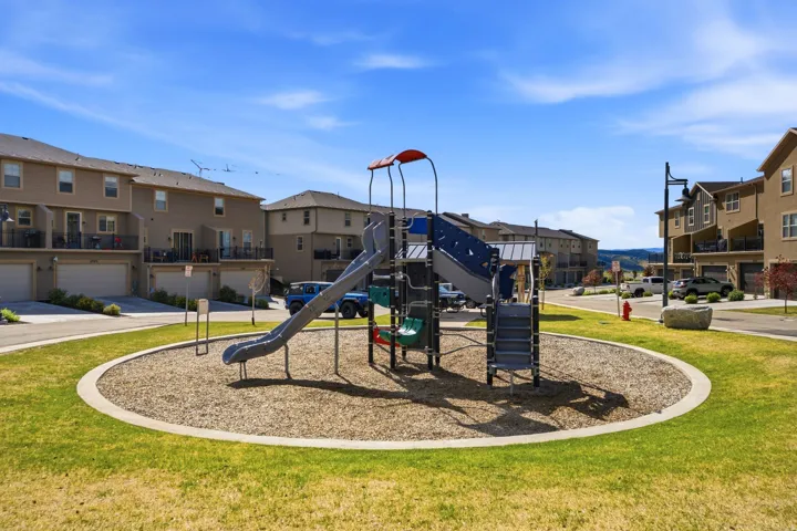 Community playground featuring a multi-level structure with slides, swings, and climbing elements