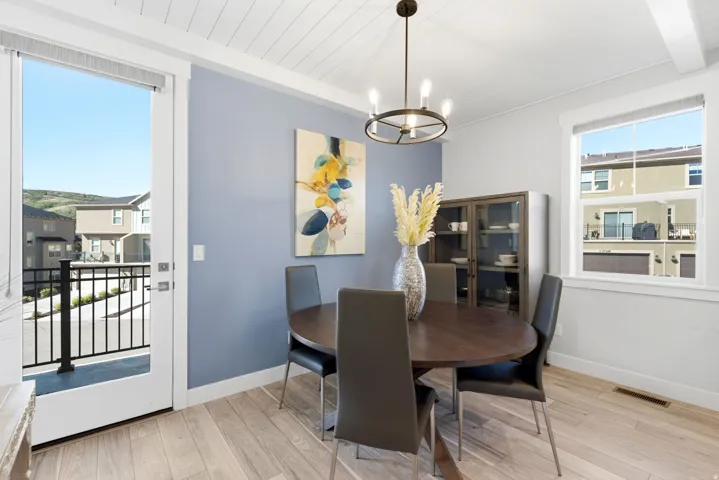 Dining area featuring light wood-finish flooring, a shiplap ceiling, and a modern chandelier