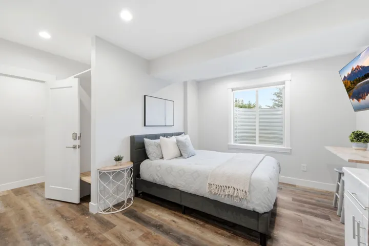 Bedroom featuring wood-finish flooring, recessed lighting, and a window with white trim