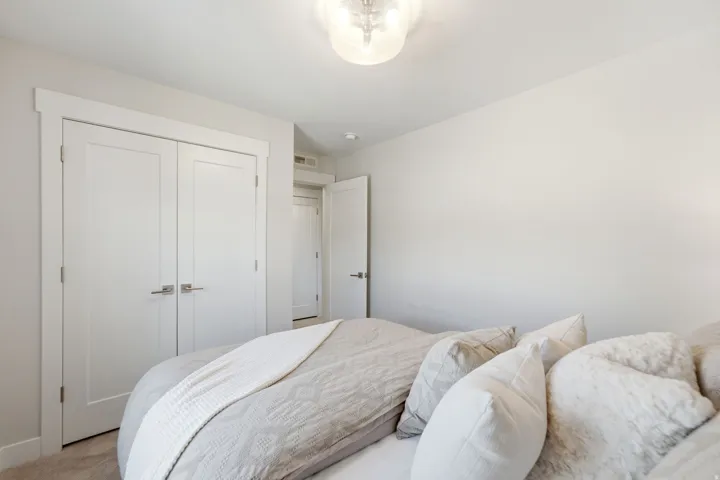 Bedroom featuring light neutral walls, white trim, and a flush mount lighting fixture