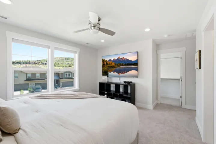 Bright interior space featuring a ceiling fan with integrated lighting, recessed ceiling lighting, and expansive windows