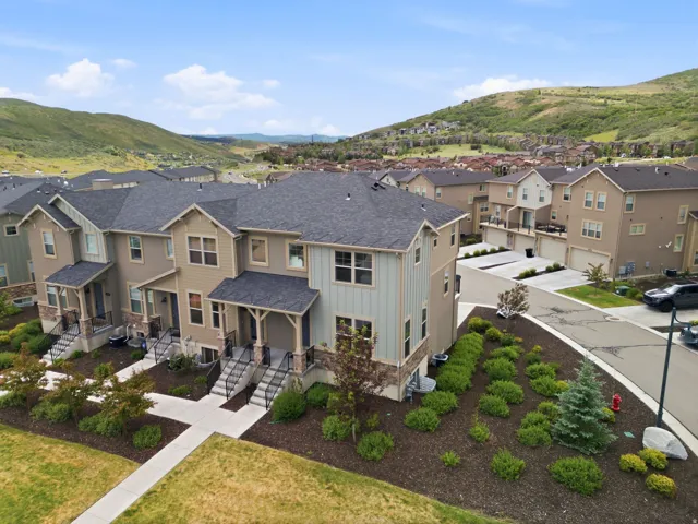 Townhome exterior featuring varied siding materials, stone accents, and covered entryways