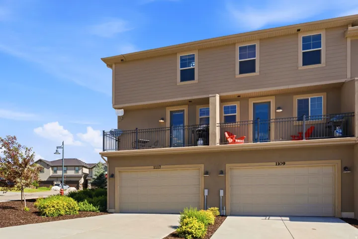 Two-story townhome with neutral-toned siding and stucco exterior