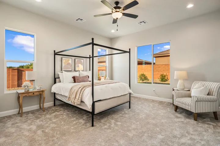 Spacious carpeted room featuring recessed lighting, a ceiling fan with integrated lighting, and multiple windows