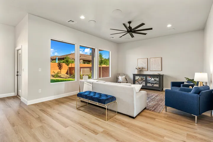 Spacious room featuring light wood-finish flooring, recessed lighting, and a contemporary ceiling fan