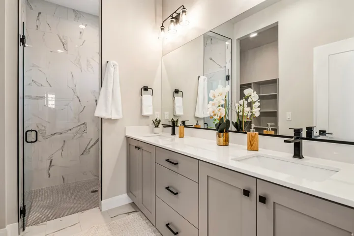 Double vanity with quartz countertops, undermount sinks, and matte black fixtures