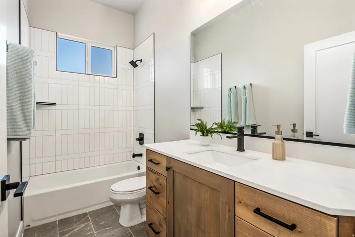 Modern bathroom featuring a wood-finish vanity with a white countertop and integrated sink
