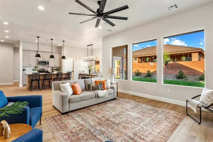 Open-concept living space featuring wood-finish flooring and ample natural light from multiple large windows