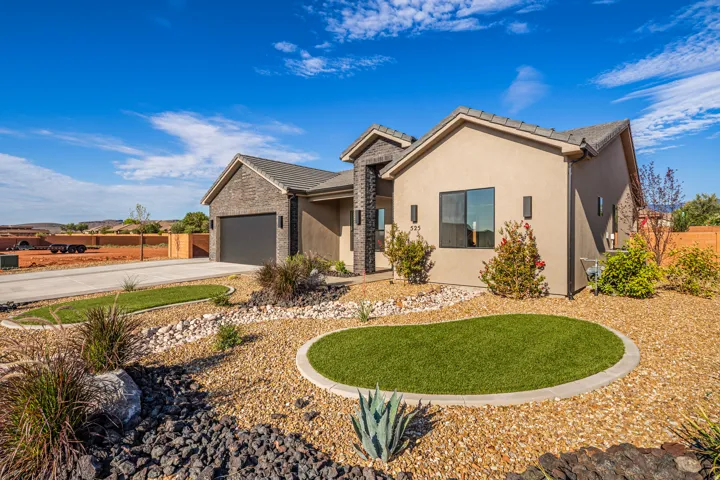 Contemporary stucco exterior featuring a stone accent column and garage facade