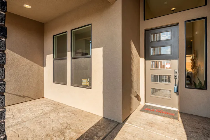 Entryway featuring a modern door with multiple glass panes, an accompanying side light, and an overhead transom window