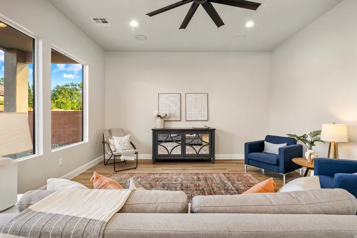 Spacious living area featuring light wood-finish flooring and ample natural light from large windows