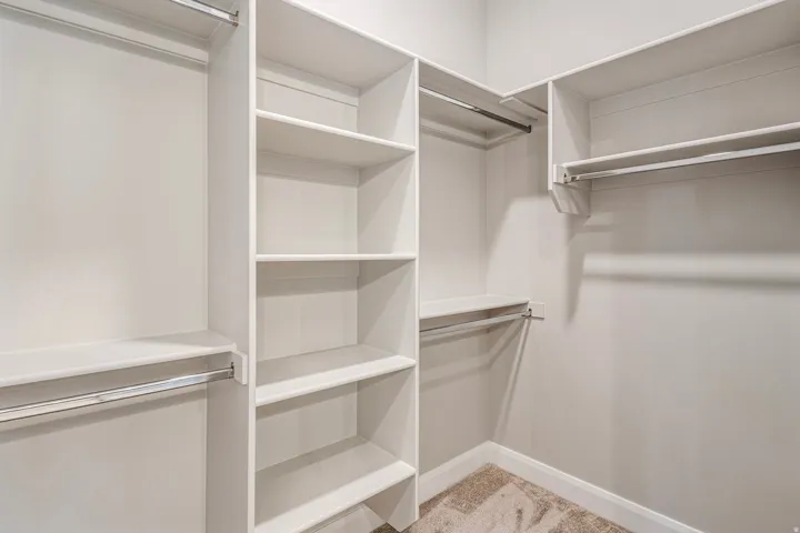 Custom closet system featuring multiple shelves, hanging rods, and corner storage