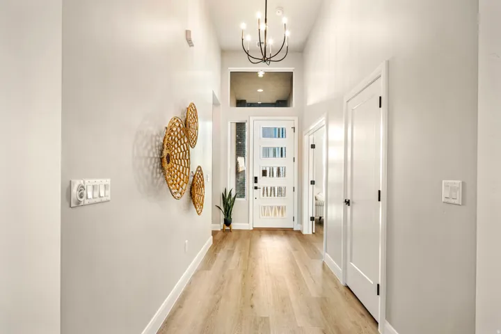 Entryway featuring wood-finish flooring, a contemporary chandelier, and a transom window above the front door