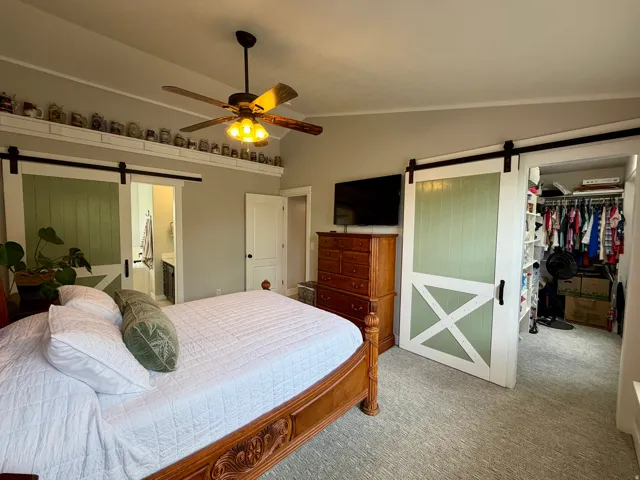 Bedroom featuring a ceiling fan with integrated lighting, a decorative ledge, and light gray wall paint