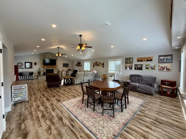 Spacious open-concept living area featuring wood-finish flooring, recessed lighting, and a vaulted ceiling