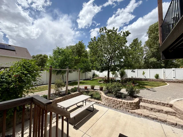 Expansive backyard featuring a tiered hardscaped patio with concrete and gravel surfaces