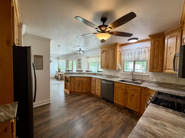 Spacious kitchen featuring wood-finish flooring, light wood cabinetry, and extensive countertop space