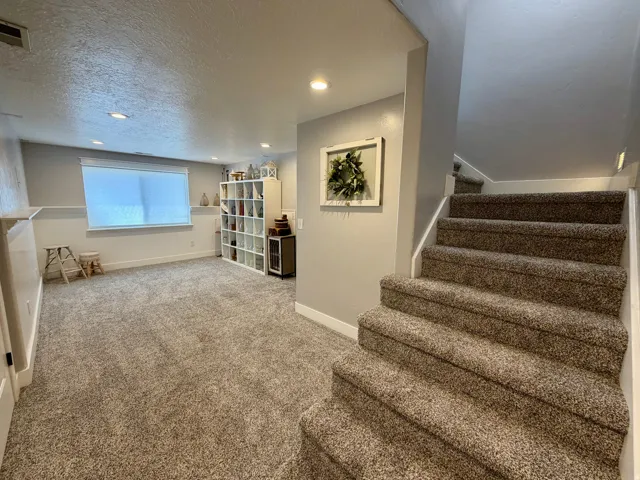 Lower level featuring soft carpet flooring, recessed lighting, and a built-in shelving unit