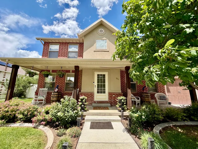 Brick and stucco exterior with a covered porch featuring dark wood columns