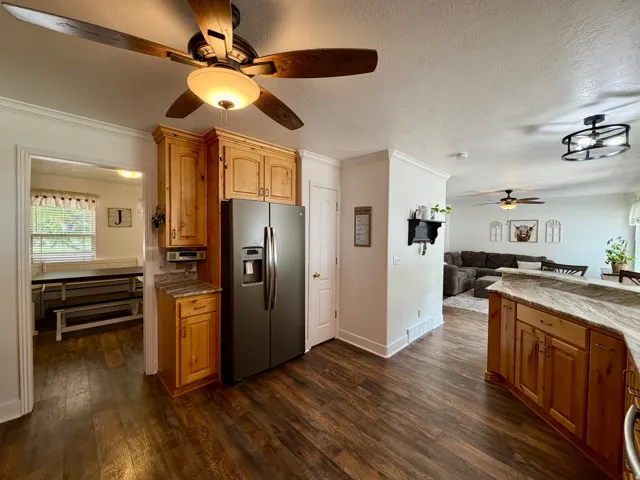 Spacious kitchen featuring wood-finish flooring, light wood cabinetry, and a modern stainless steel refrigerator