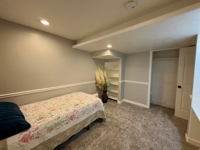 Room featuring grey carpeting, recessed lighting, and a white chair rail molding