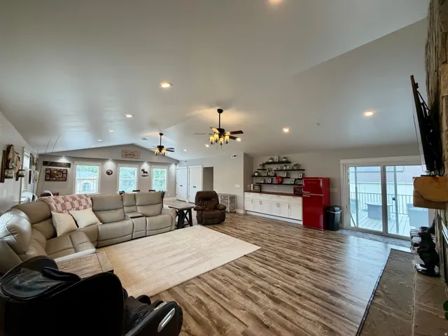 Expansive living area featuring vaulted ceilings, wood-finish flooring, recessed lighting, and ceiling fans