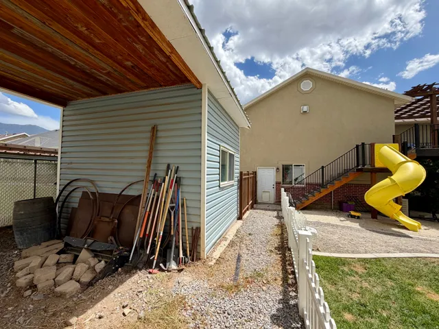 Detached auxiliary structure with horizontal siding and a wood-finish ceiling under a covered area